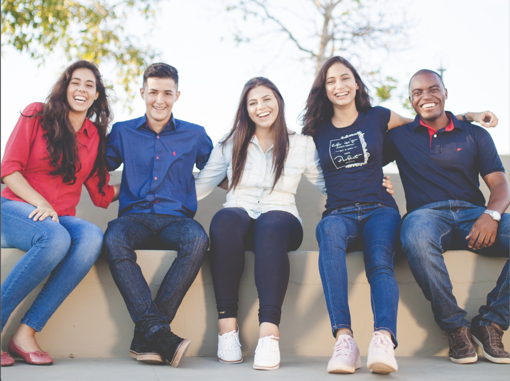 Group of 5 high school students sitting down and smiling